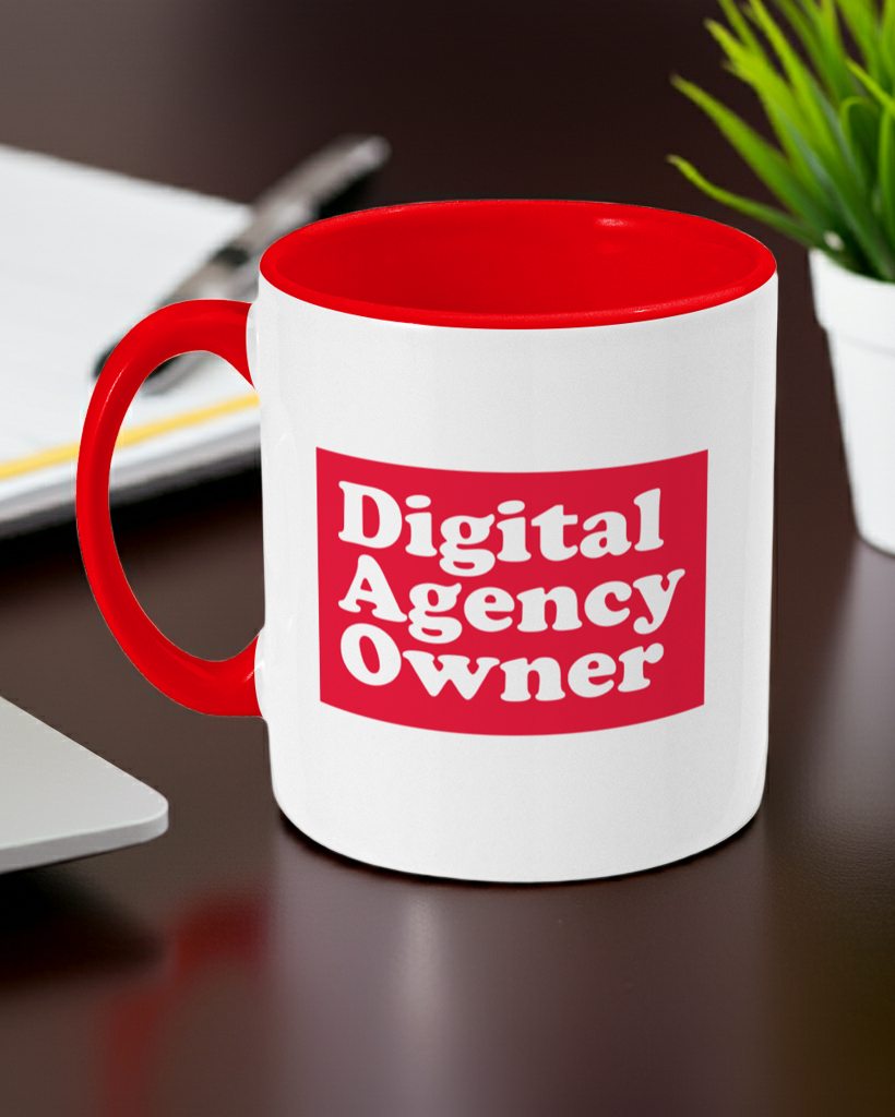 White mug with red interior and handle, featuring 'Digital Agency Owner' text, on a desk.