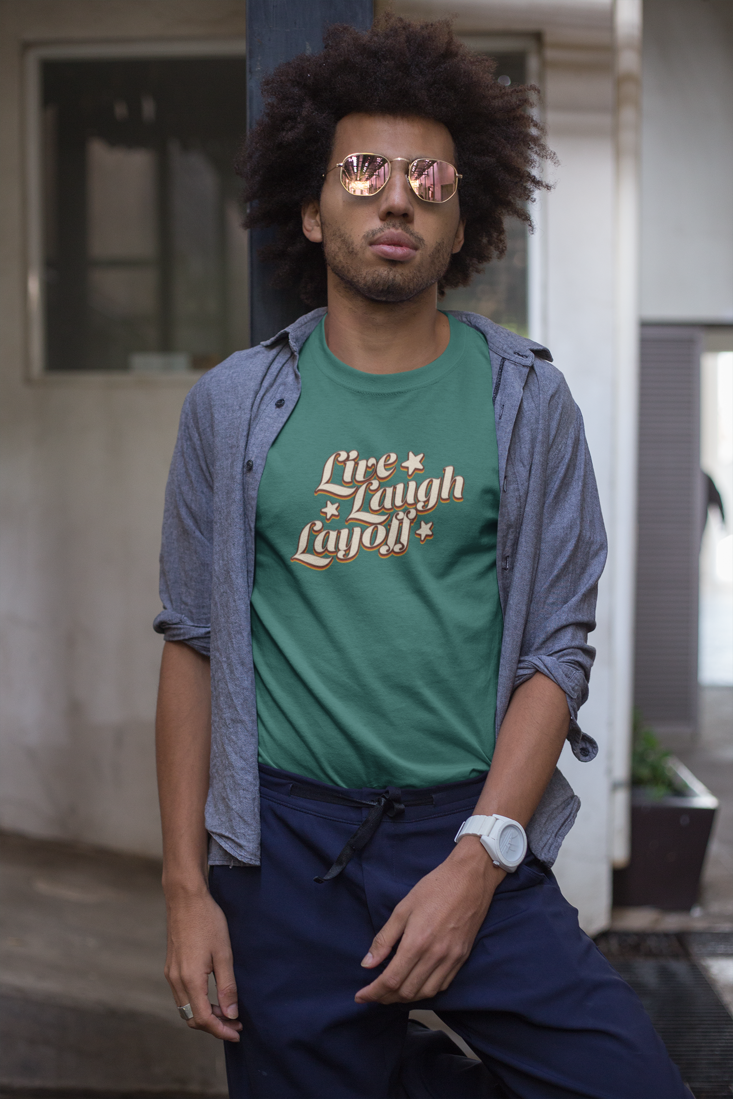 Live Love Layoff Humorous TShirt Man Man wearing a green t-shirt with text and a blue shirt over it, standing outdoors.