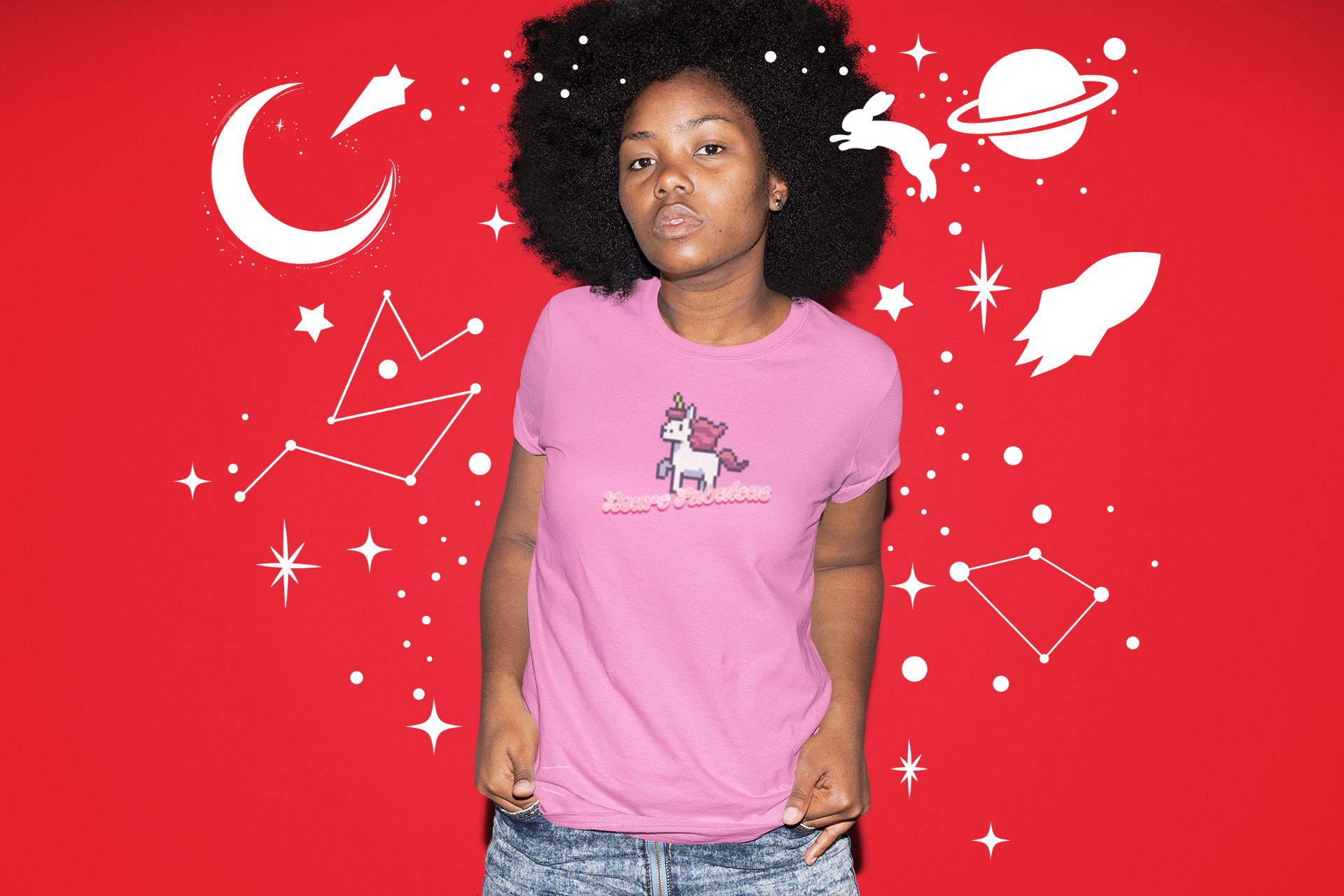 Person wearing a pink t-shirt with a unicorn design on a red background with celestial graphics