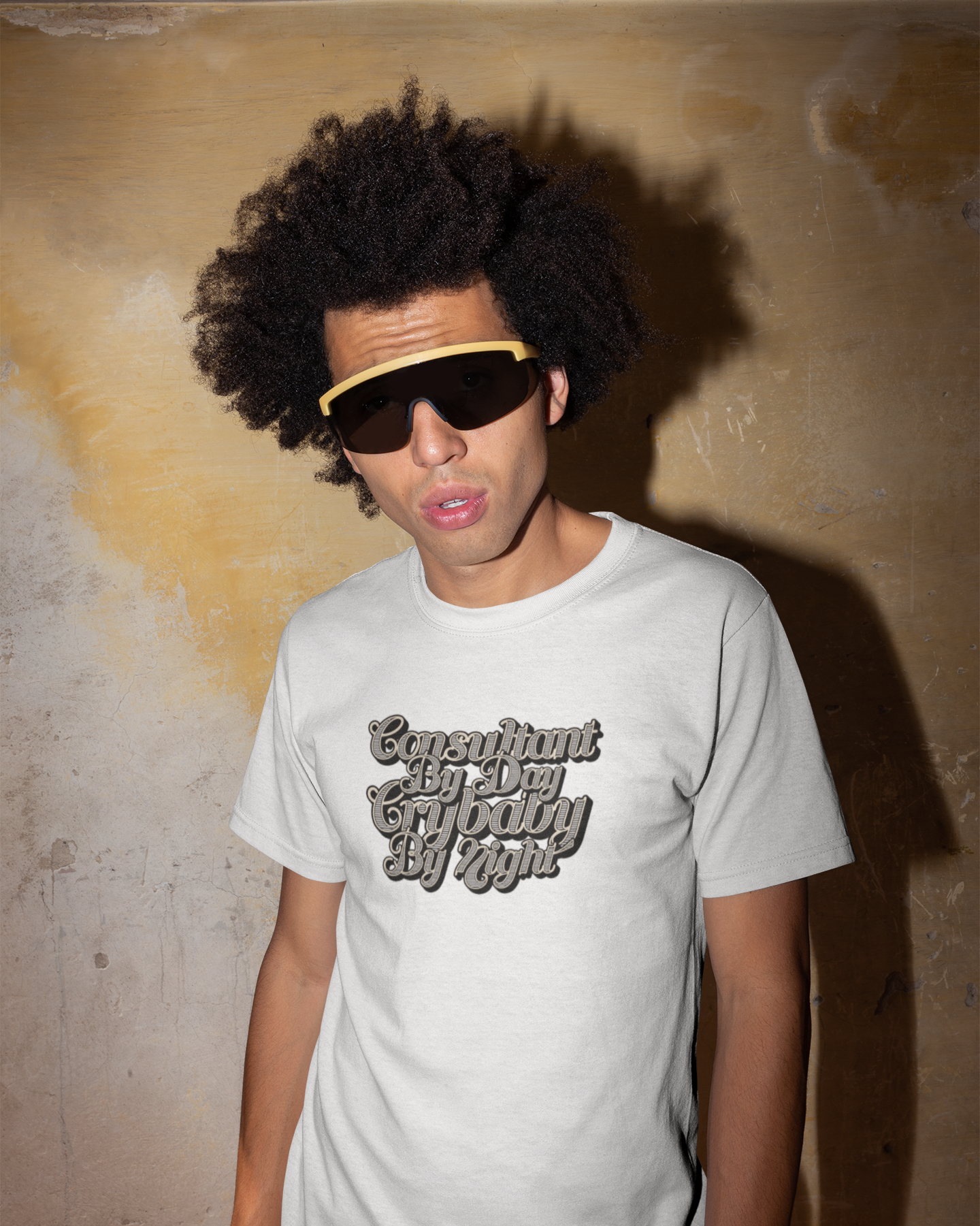 Organic Cotton Funny Consultant T-Shirt Person wearing a light gray t-shirt with text, standing against a textured wall.