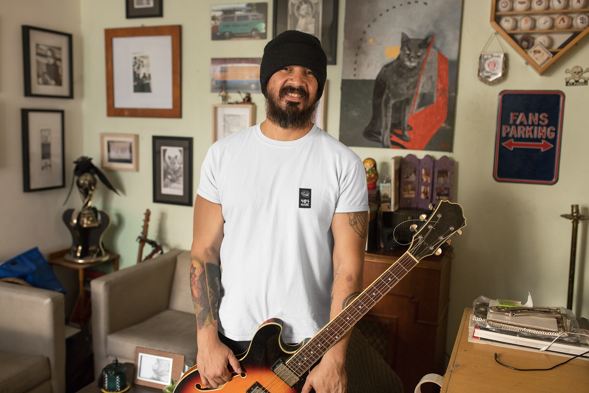 Organic Cotton T-Shirt 404 Troll  Man holding a guitar in a room with various decorations and furniture.