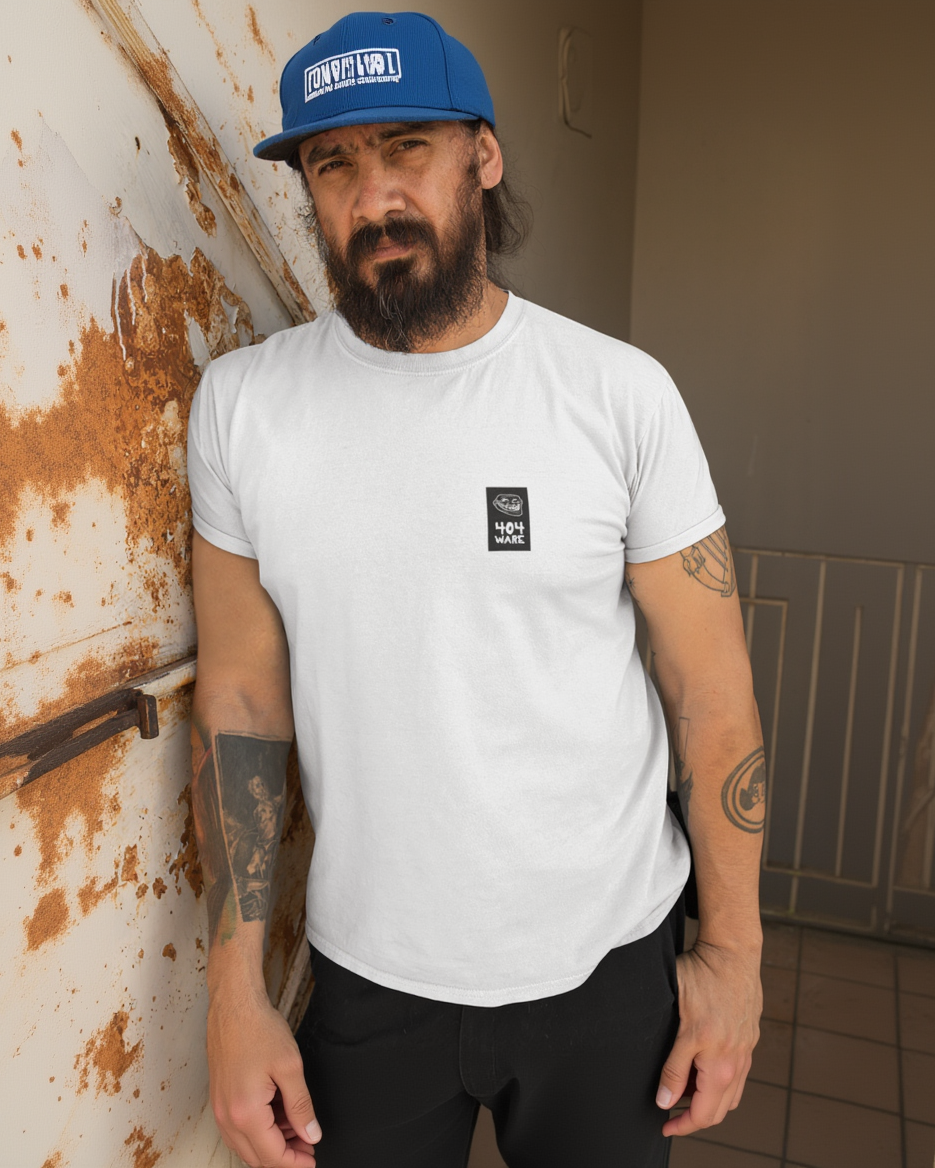 Organic Cotton T-Shirt 404 Troll Man wearing a white t-shirt with a small black logo, standing against a rusty metal wall.