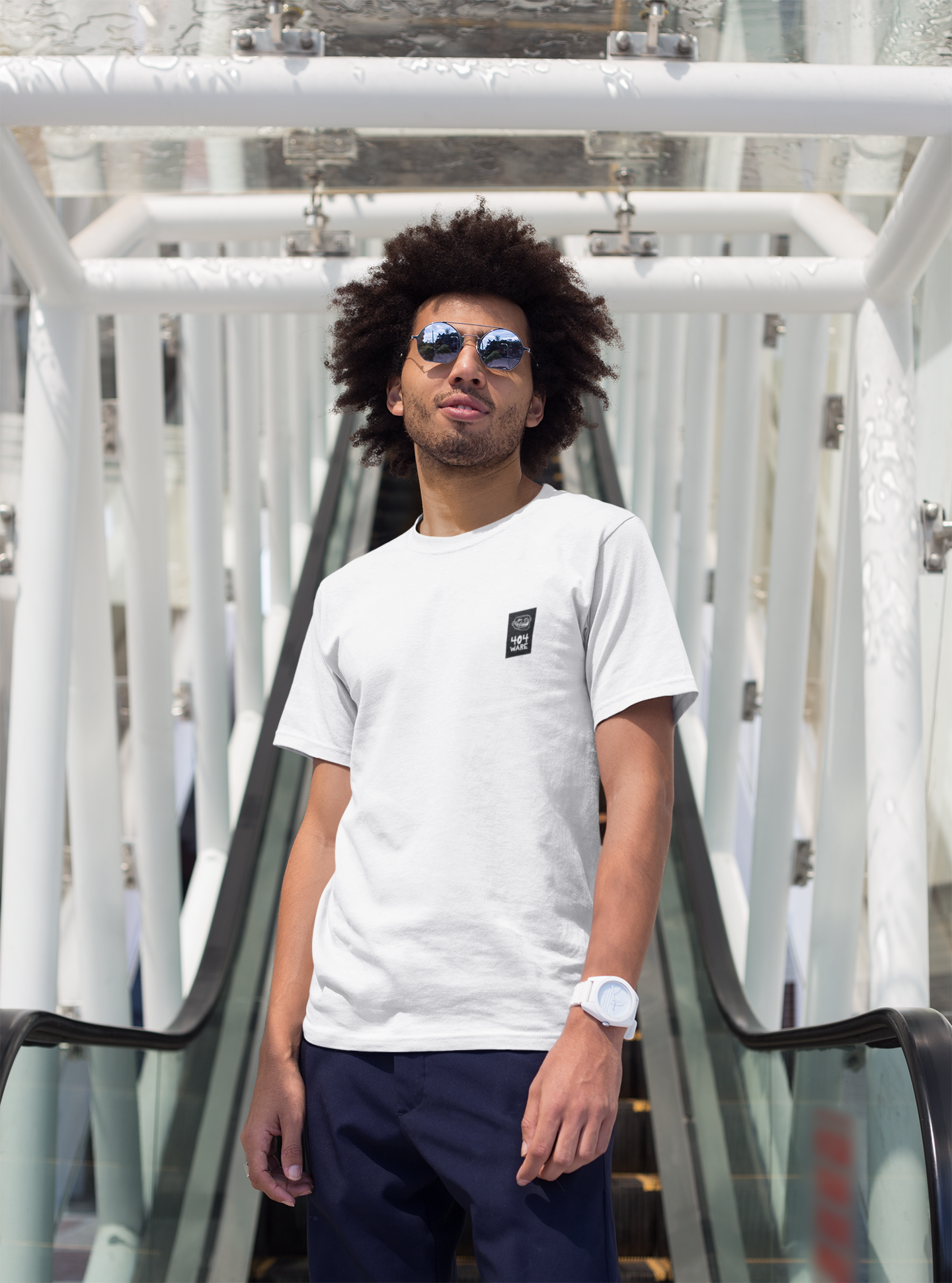 Organic Cotton T-Shirt 404 Troll Man wearing a white t-shirt with a small logo and sunglasses, standing on a modern architectural background.