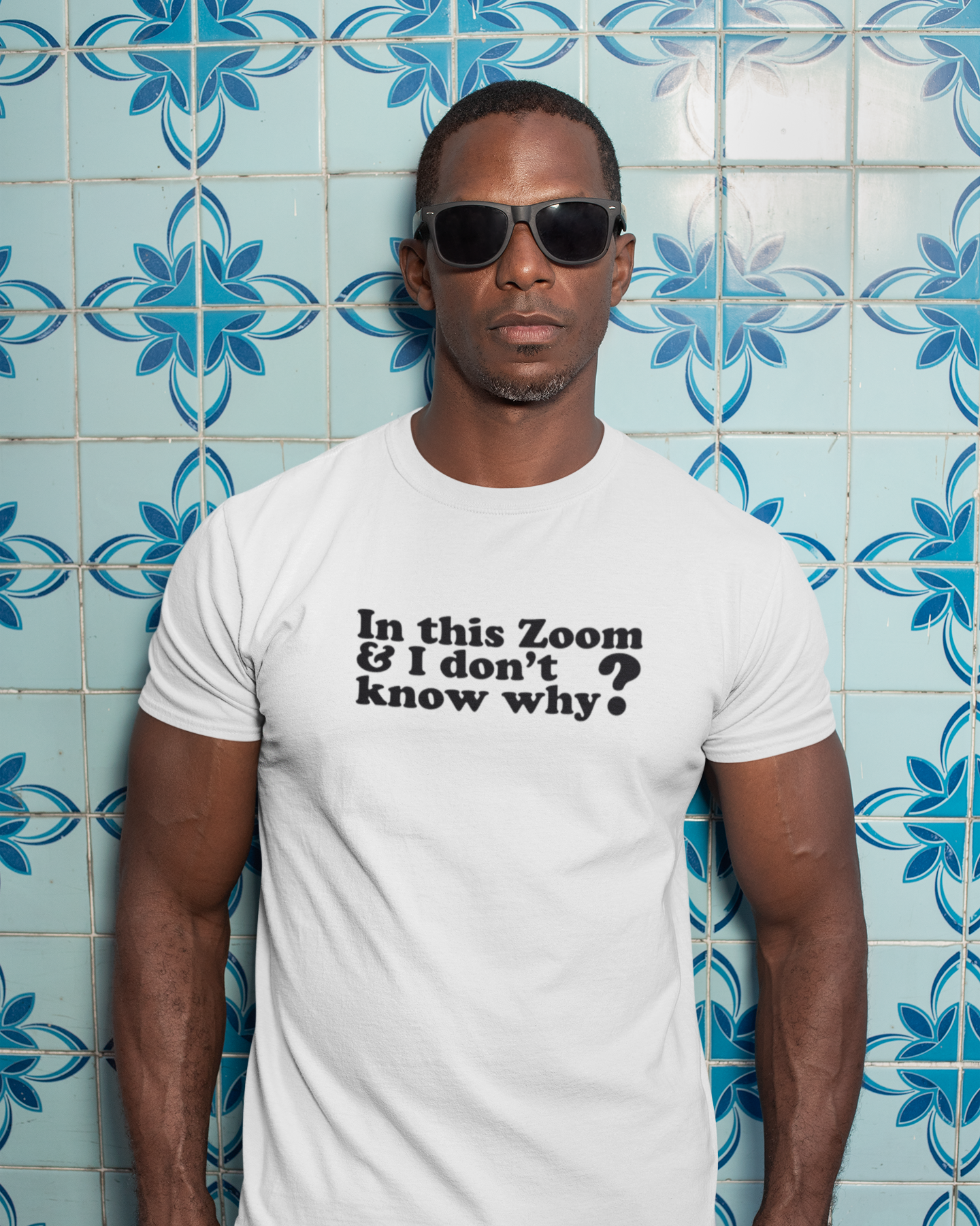 Organic Tee I'm In This Zoom Don't Know Why Man wearing a white t-shirt with text in front of a blue tiled wall.