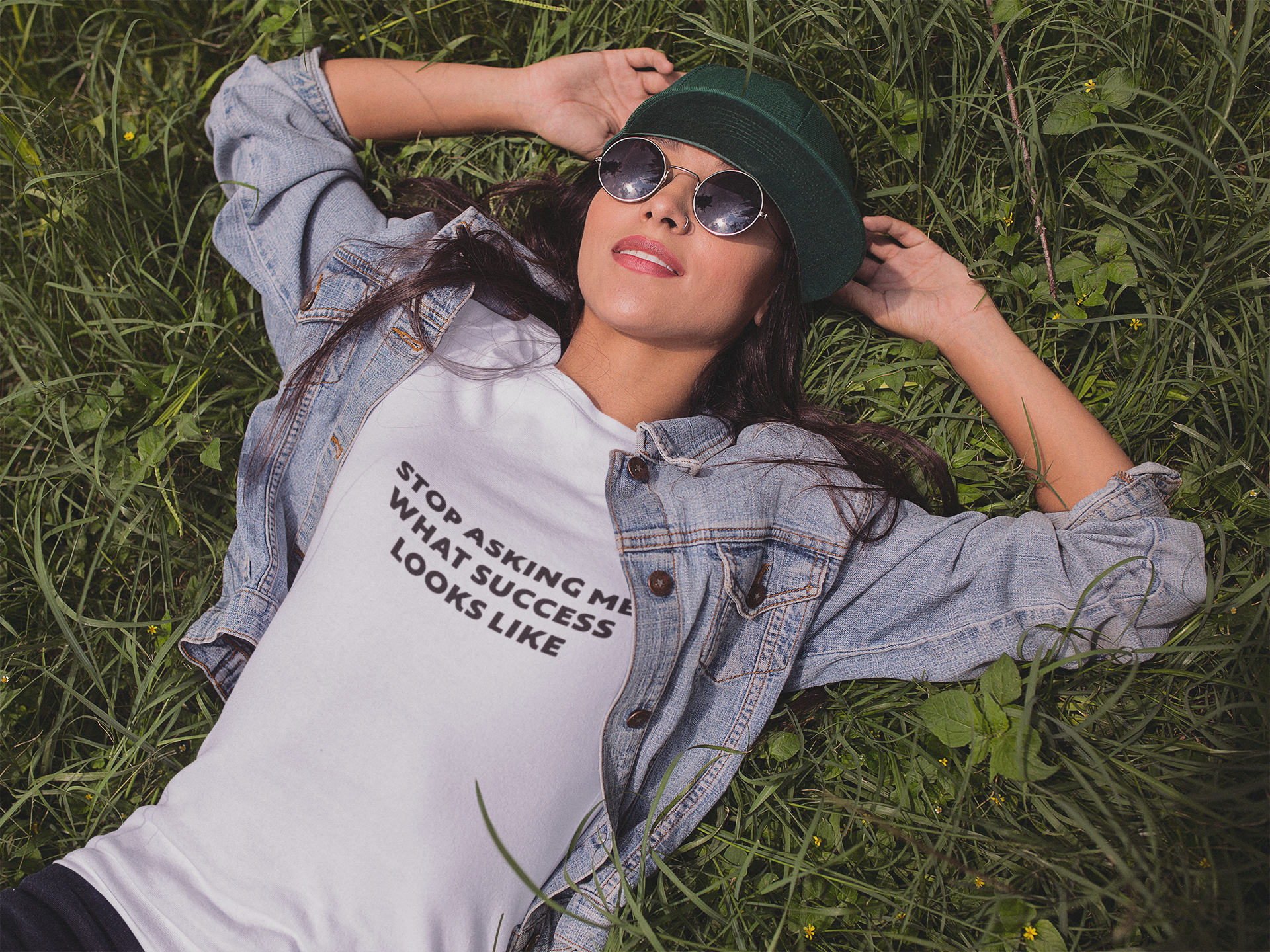 Stop Asking What Success Looks Like Person wearing a pink t-shirt with a unicorn design lying on grass