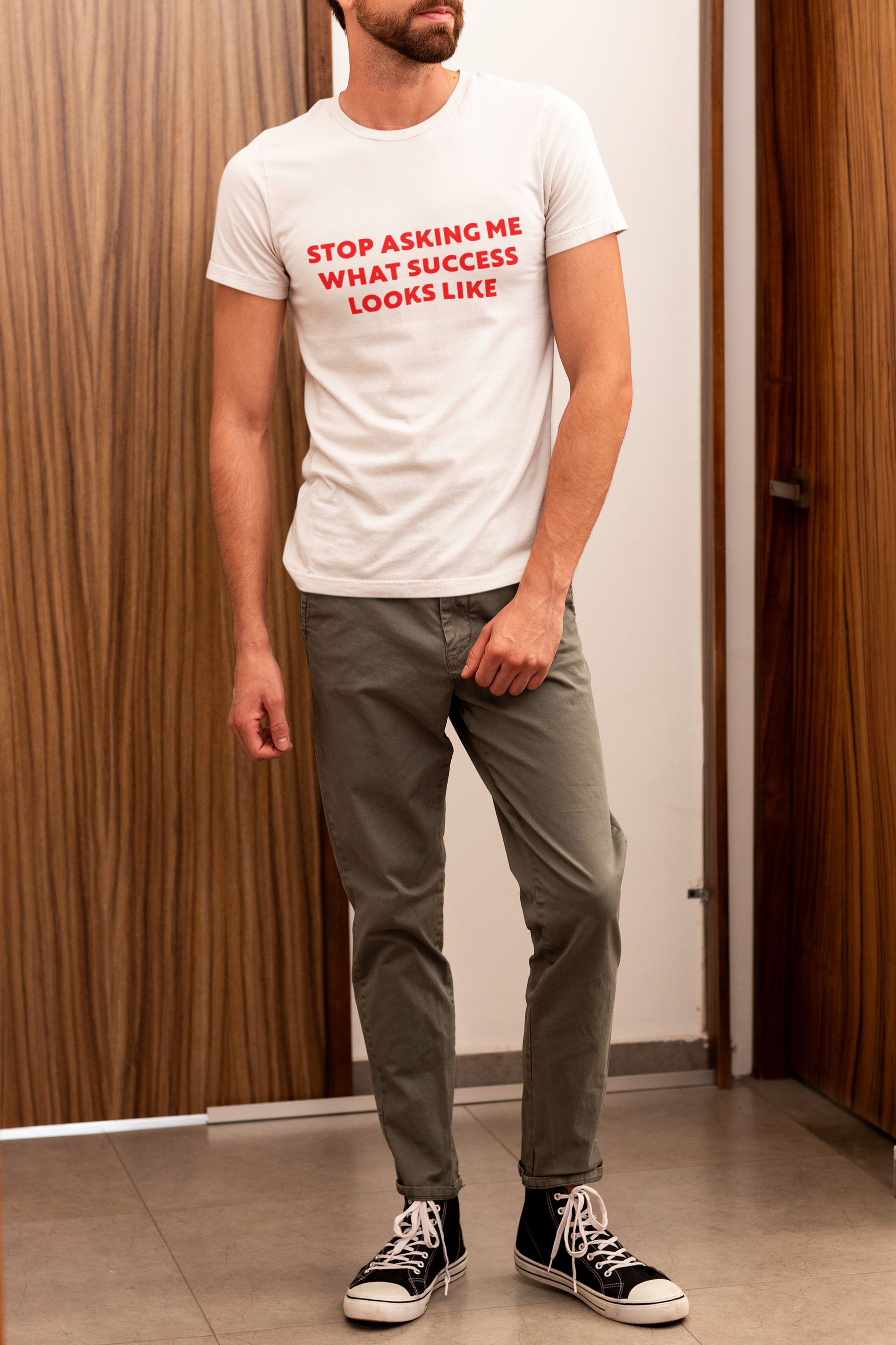 Stop Asking What Success Looks Like  T-Shirt Person wearing a white t-shirt with red text in an indoor setting