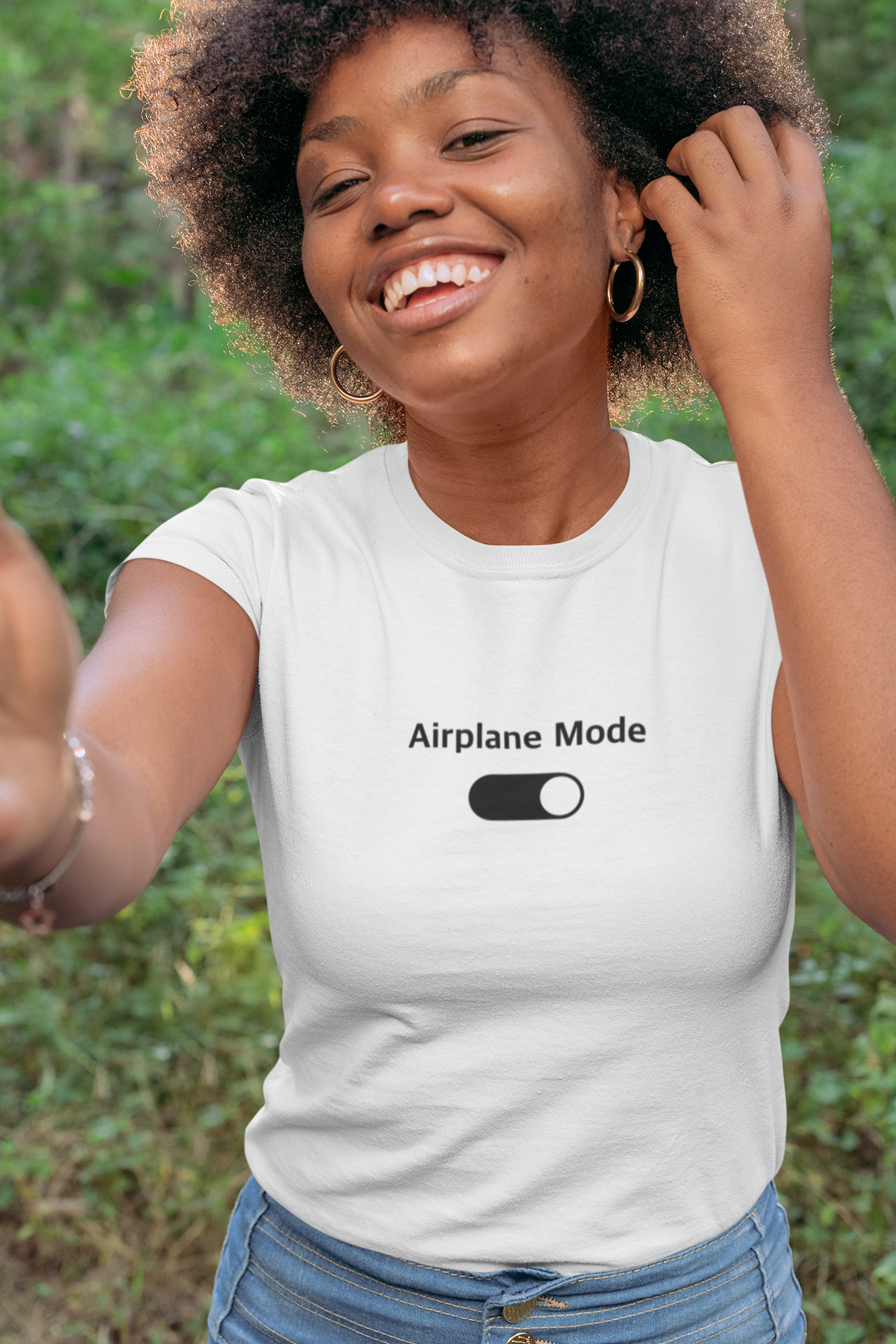 Woman wearing a white t-shirt with 'Airplane Mode' design outdoors