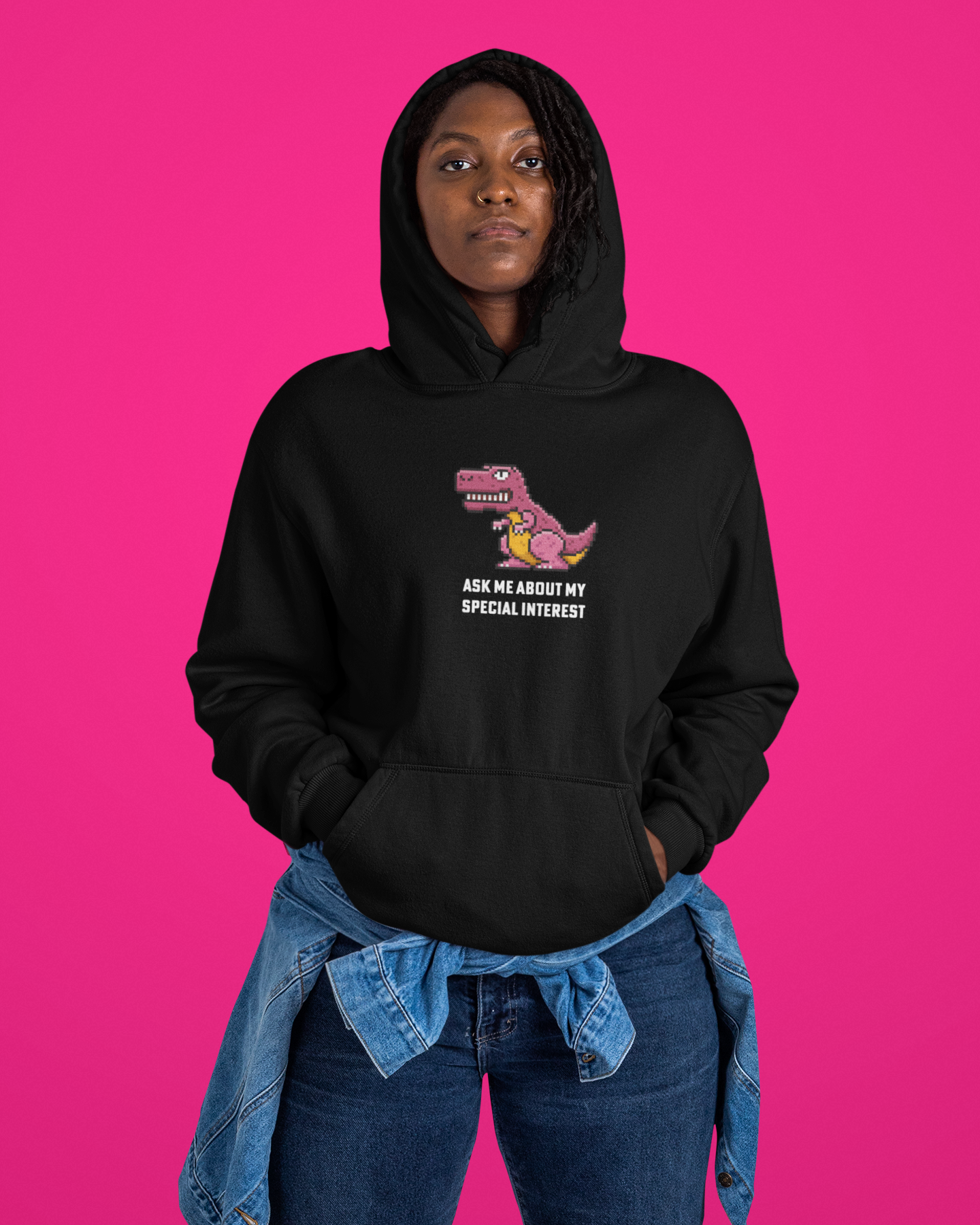 Person wearing a black hoodie with a graphic and text on a pink background