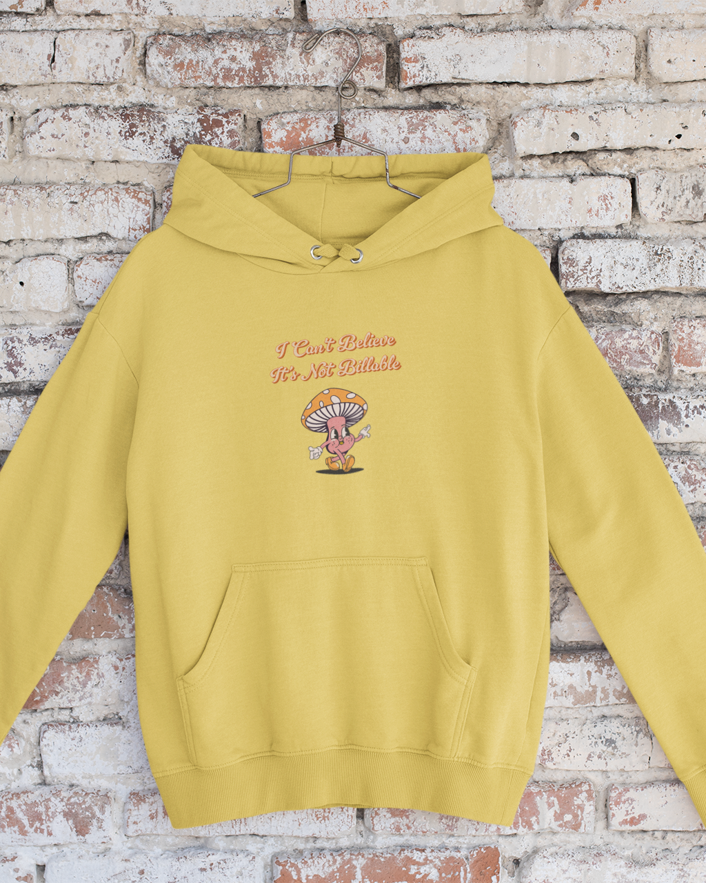 Yellow hoodie with text and graphic on a brick wall background