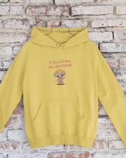Yellow hoodie with text and graphic on a brick wall background