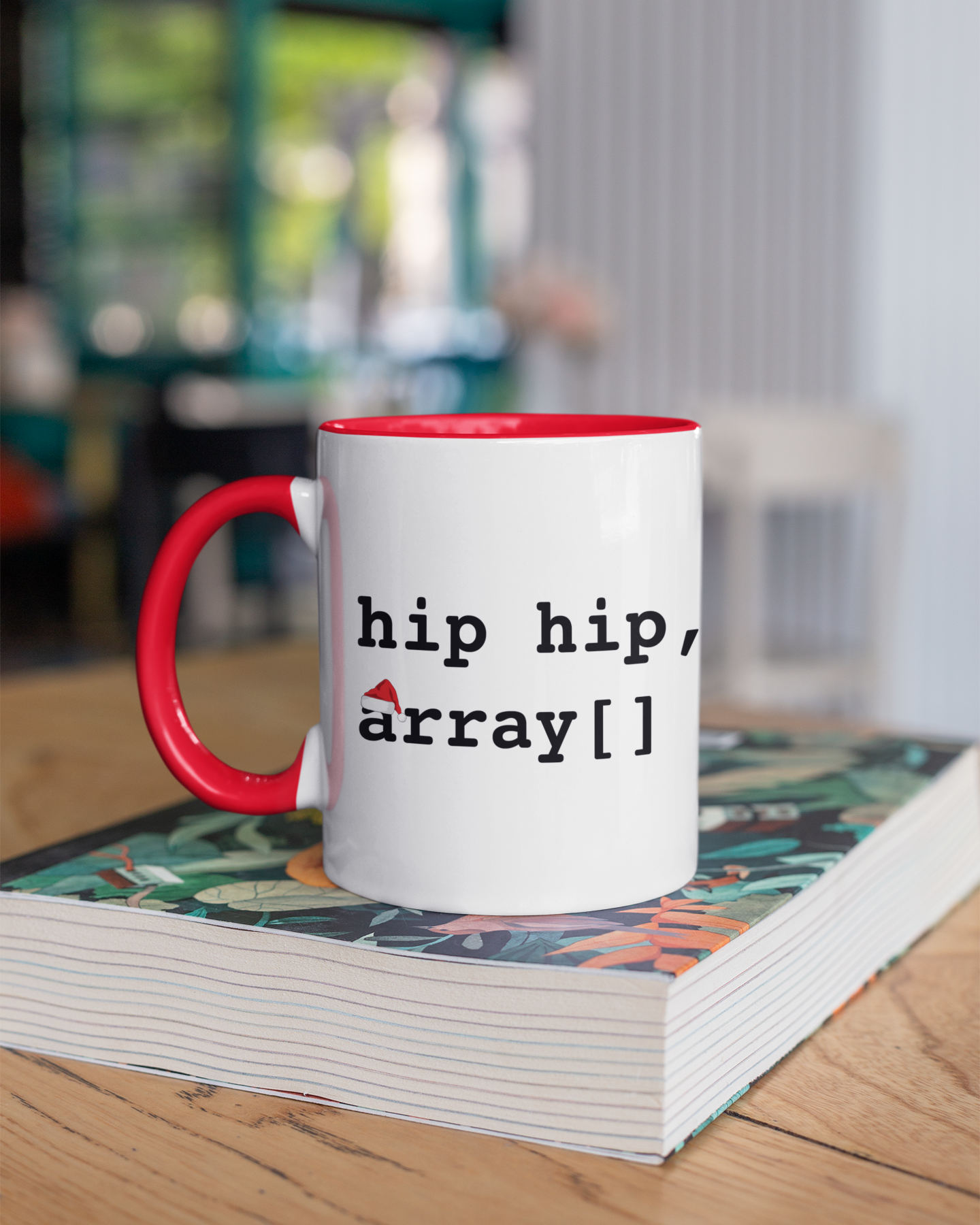 Mug with 'hip hip, array[]' text on a stack of books with a blurred background