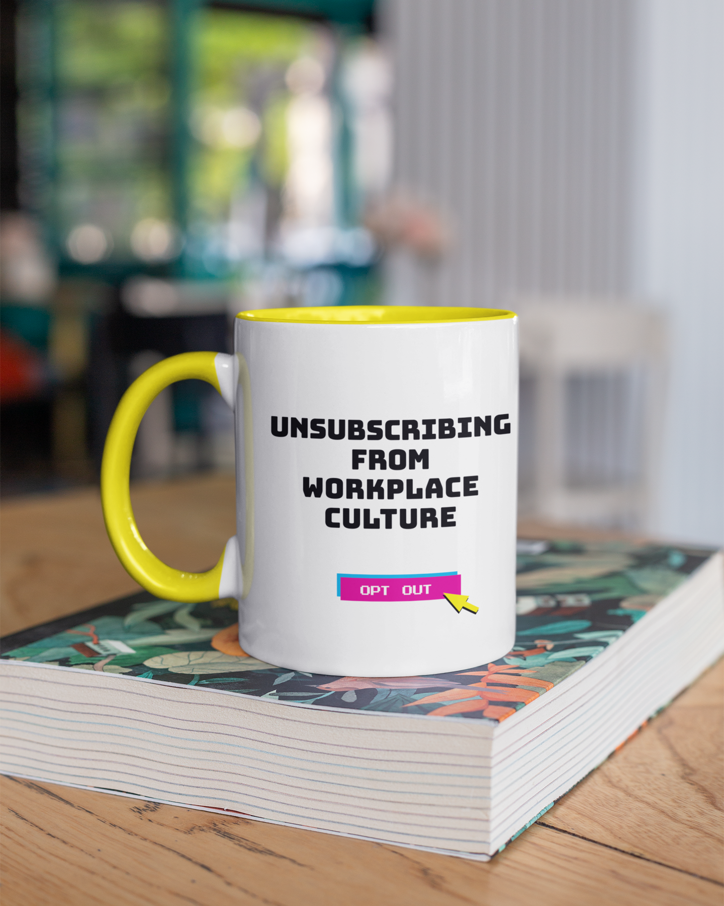 Mug with 'Unsubscribing from Workplace Culture' text on a stack of books