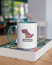 Mug with dinosaur graphic and text on a stack of books
