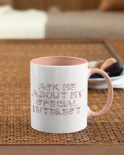 Mug with 'Ask me about my special interest' text on a woven mat