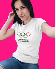Woman wearing a white t-shirt with Olympic logo and text against a pink background